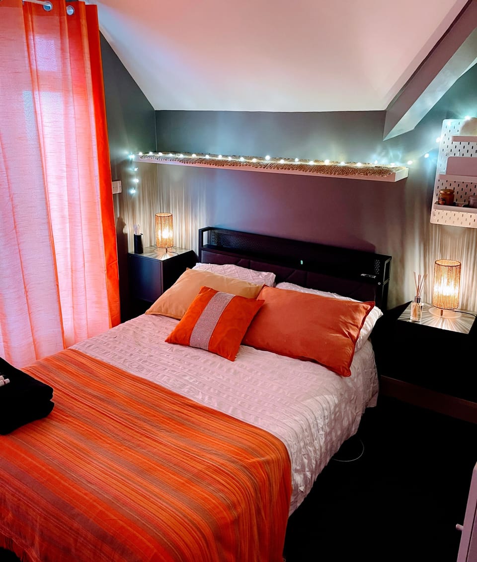Double bedroom in burnt orange and grey tones opens out onto a 25 foot terrace