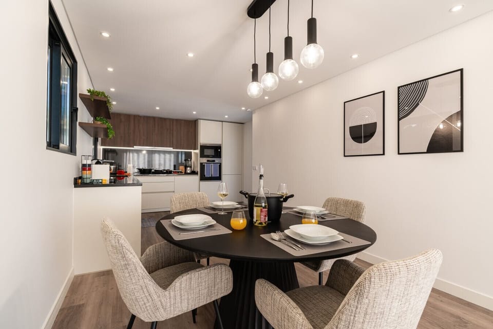 Dining area with open kitchen and soft lighting.