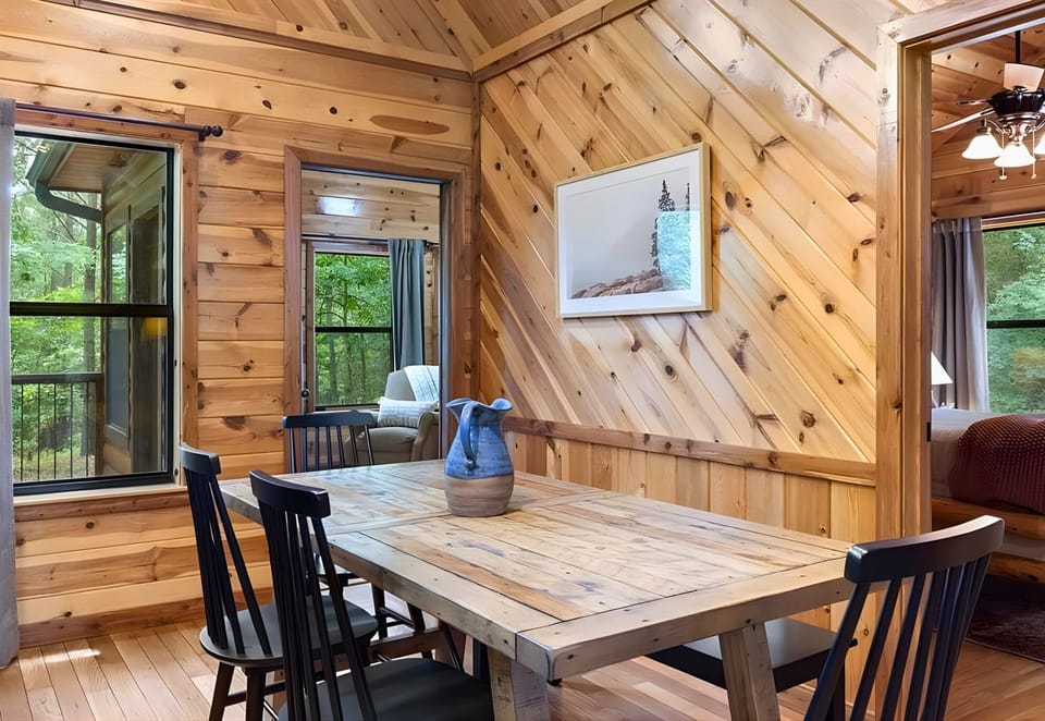 A second look at the dining nook brings in extra charm with its forest views and cozy cabin feel.