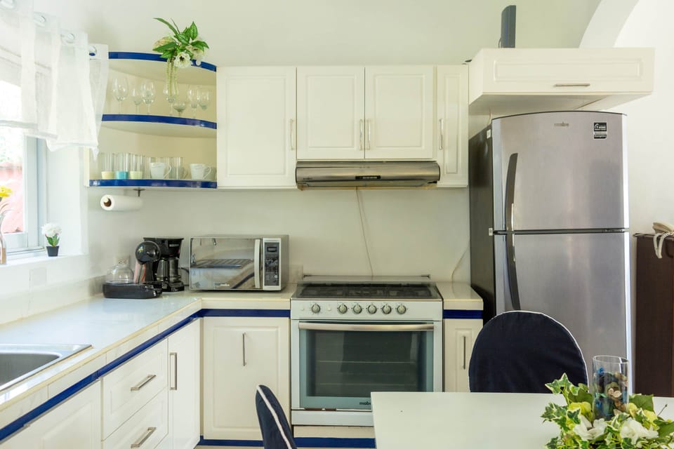 Kitchen is fully stocked with dishes and appliances. 
