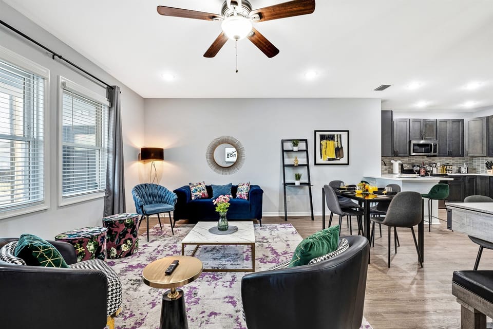 A bright and stylish living area featuring bold pops of color, modern décor, and plenty of seating for everyone to relax.