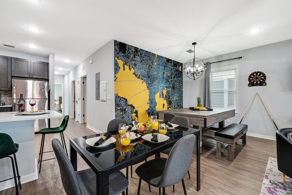 Enjoy meals and game nights in this vibrant room equipped with a pool table, dartboard, and sleek dining setup.