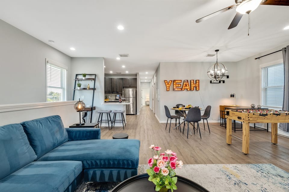Designed for comfort and style, this living space boasts a bold blue sectional, a vibrant accent chair, and contemporary décor details.