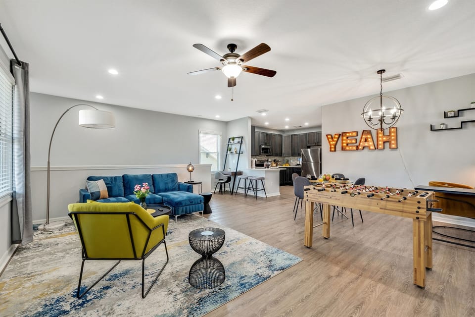 A chic and inviting living room offering plush seating, a smart TV, and a seamless flow into the dining and kitchen areas.