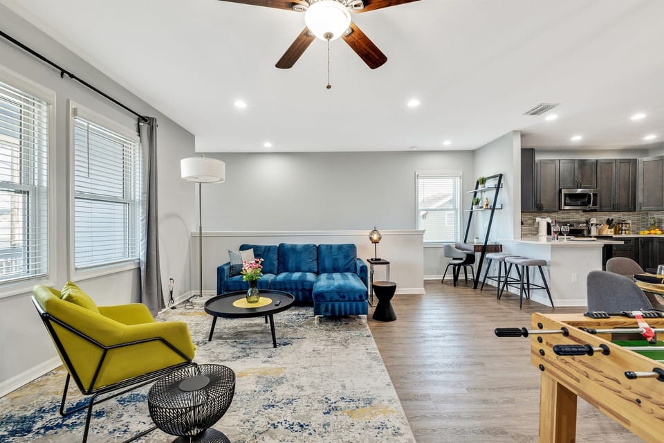 A bright and spacious living room featuring bold designer seating, modern décor, and plenty of natural light—perfect for relaxing or entertaining.