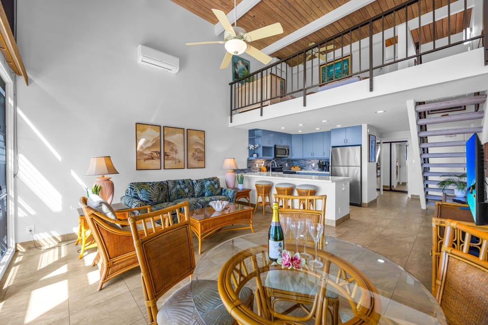 Open flow between the living area and the fully equipped kitchen. Plus, you can see the cool loft area upstairs overlooking everything—it's a great extra hangout space!