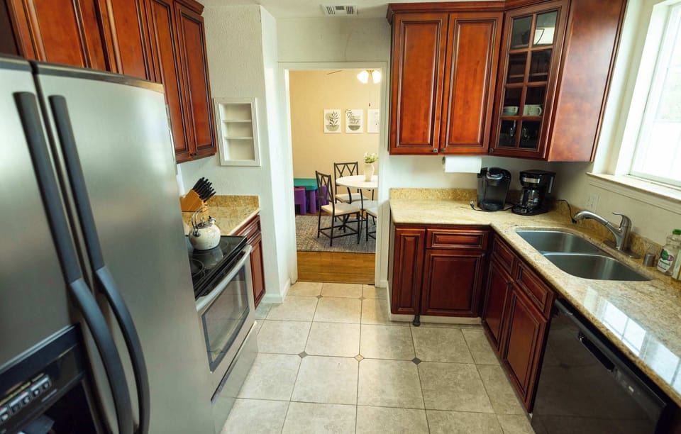 Cook with ease in this warm and functional kitchen featuring rich wood cabinetry, sleek stainless steel appliances, and plenty of counter space for meal prep