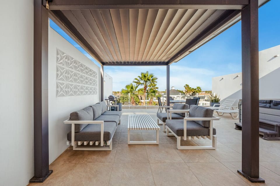 Covered outdoor lounge with comfy seating, perfect for morning coffee, sunset drinks, or relaxing in the warm island breeze.
