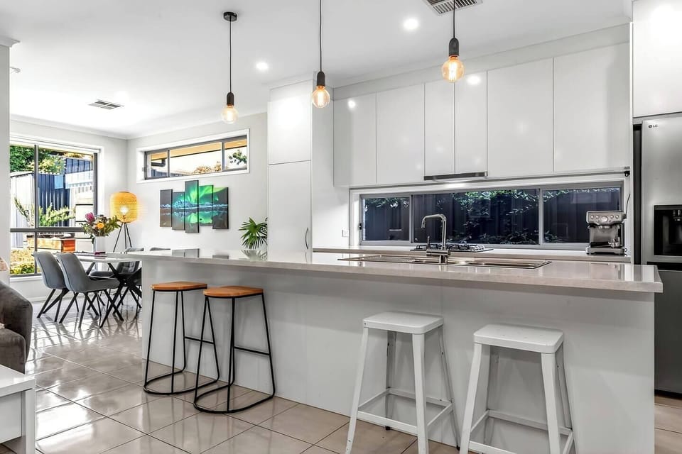 The island with stools encourages casual dining and relaxed conversation as meals come together in the bright, thoughtfully designed kitchen.