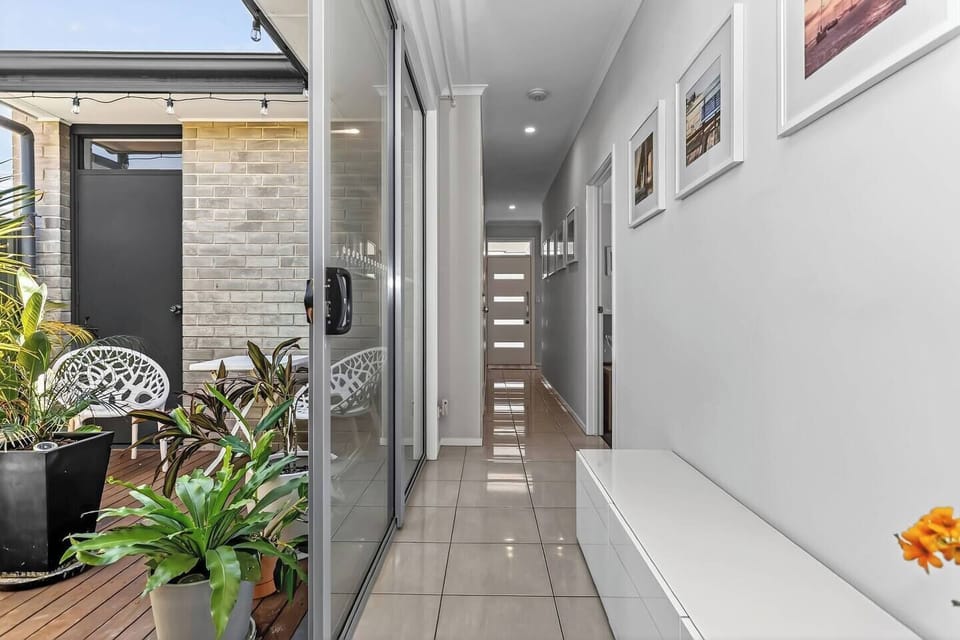 The hallway leads directly to a tranquil courtyard, adding space, brightness and a touch of nature to the home’s modern layout.