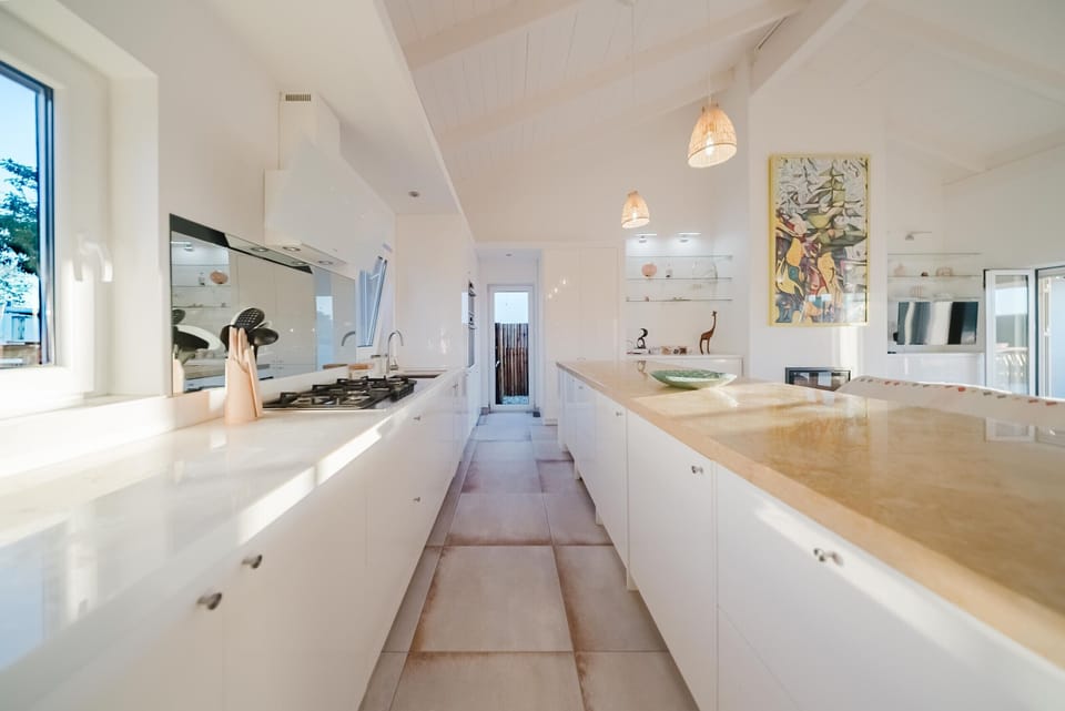 Modern white galley kitchen with wooden countertops — Villa Verso Comporta, luxury holiday villa in Alcácer do Sal
