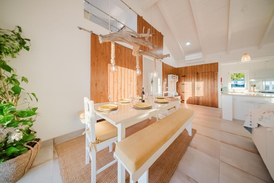 Spacious dining room with wooden feature wall and suspended driftwood installation — Villa Verso Comporta, luxury holiday villa in Alcácer do Sal