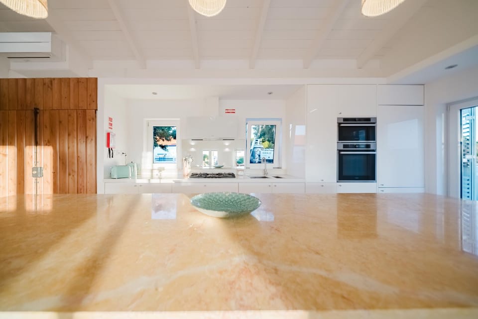 Modern kitchen with marble island and white cabinetry — Villa Verso Comporta, luxury holiday villa in Alcácer do Sal