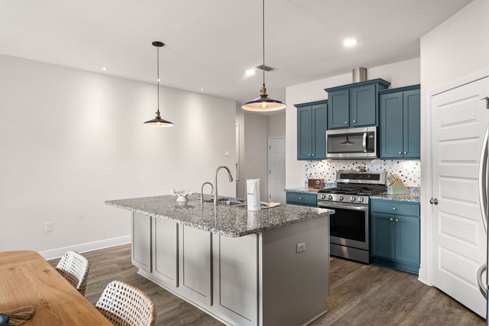 Your modern kitchen features granite countertops, stylish pendant lighting, and full-size appliances for memorable meal preparation during your stay.