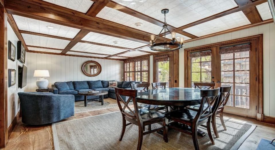 The spacious living area complements the dining space with plush seating, large windows framing spectacular mountain views, and an atmosphere of relaxed luxury.