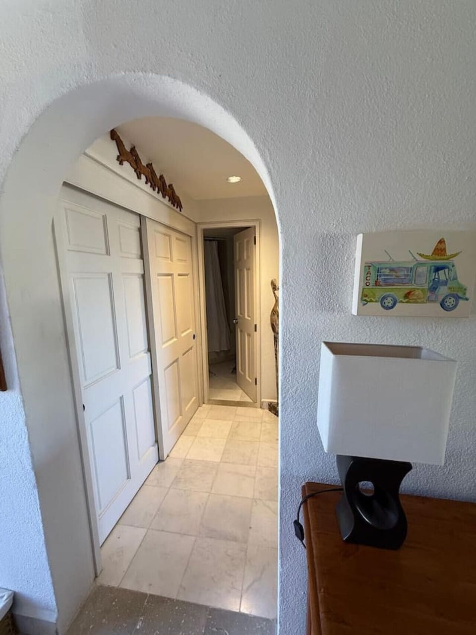 Interior archway leads past a closet and into the bathroom area, offering a glimpse of the unit`s thoughtful design.