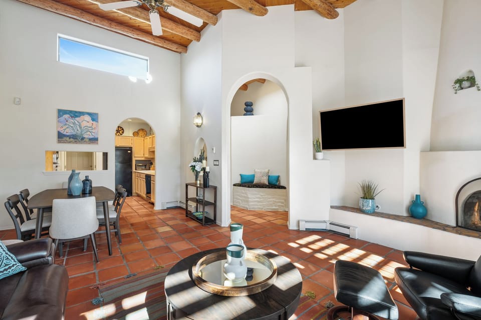 Relax in this stunning open-concept living space with soaring wood beam ceilings, cozy fireplace, and southwestern charm that invites you to unwind in style.