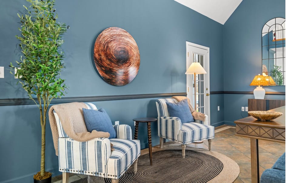 Spacious living room with plush blue sectional, Roku smart TV, cozy coffee table, and open layout to dining—enjoy mountain views through large windows and a loft balcony above.