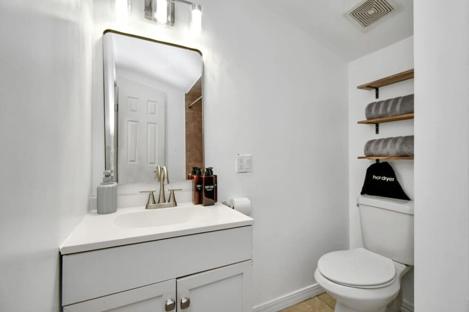 Freshen up in the modern bathroom, featuring a walk-in shower and sleek, updated fixtures for your convenience.