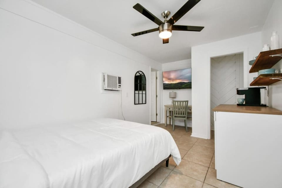 A serene bedroom with a ceiling fan and air-conditioning, perfect for unwinding after a busy day.