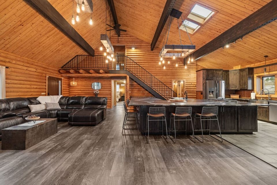 Discover unparalleled space in this log-style home, featuring an enormous great room with a stone hearth and beautiful floors, ideal for hosting memorable dinners.