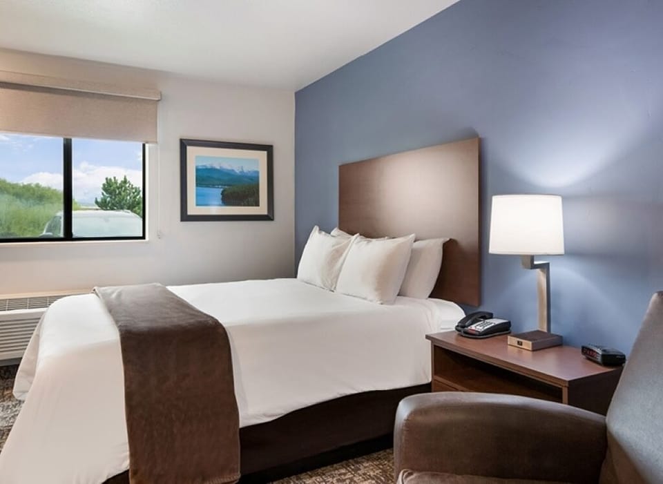 Recharge in a serene king bed with soft lamp glow.