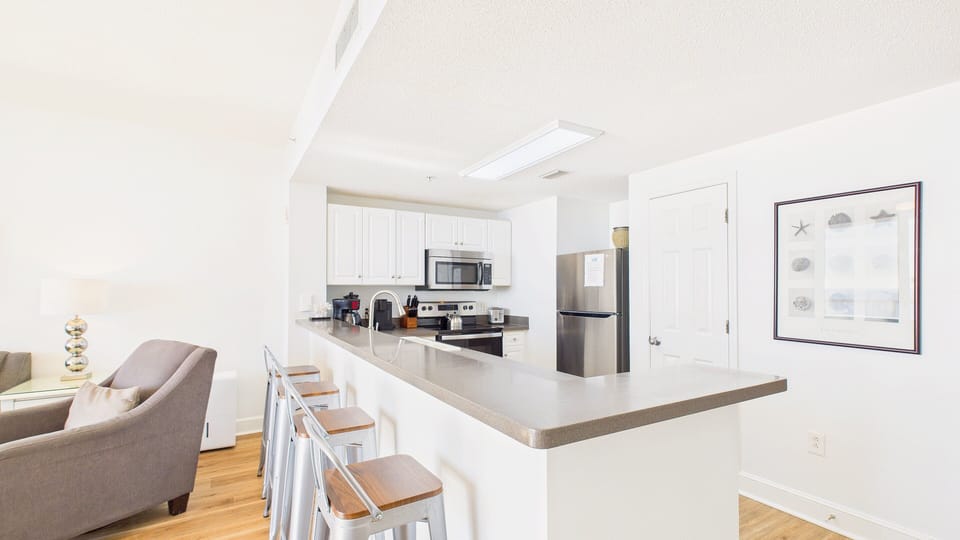 Your bright, modern kitchen features granite countertops, stainless appliances, and a breakfast bar perfect for morning coffee or casual meals.