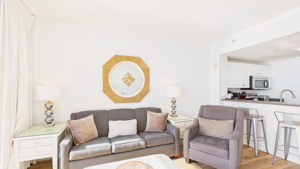 Unwind in the living area featuring a comfortable sleeper sofa and easy access to the private balcony (sleeps 2).