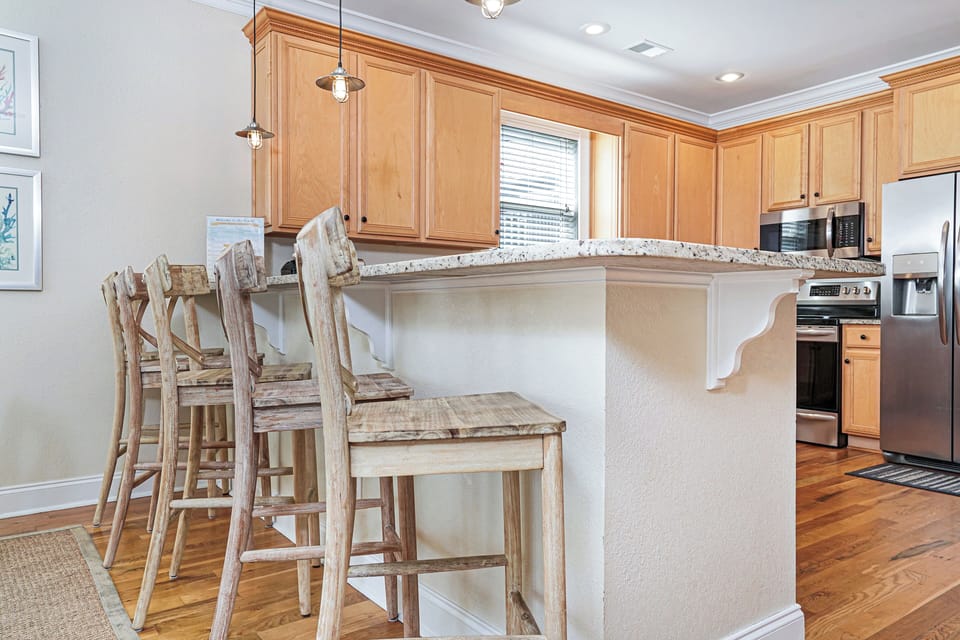 Gather around your spacious kitchen island with rustic bar stools, where granite counters and warm wood cabinets create the perfect setting for morning coffee.