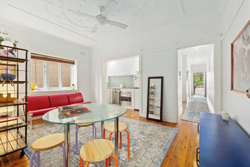 A glass dining table with colourful seating offers a bright, casual setting for shared breakfasts, simple dinners or a quick bite before heading out.