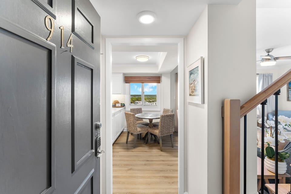 When entering the unit you are greeted by a beautiful wrought iron staircase and an open view of the dining and living room.