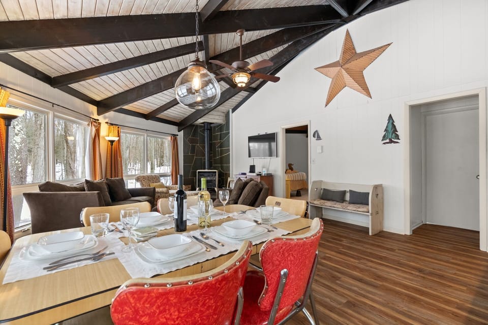 Spacious living room with soaring vaulted ceilings and floor-to-ceiling windows at Lake Naomi Pocono cabin