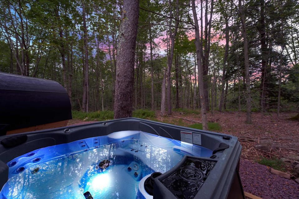 Private hot tub glowing blue in the evening light