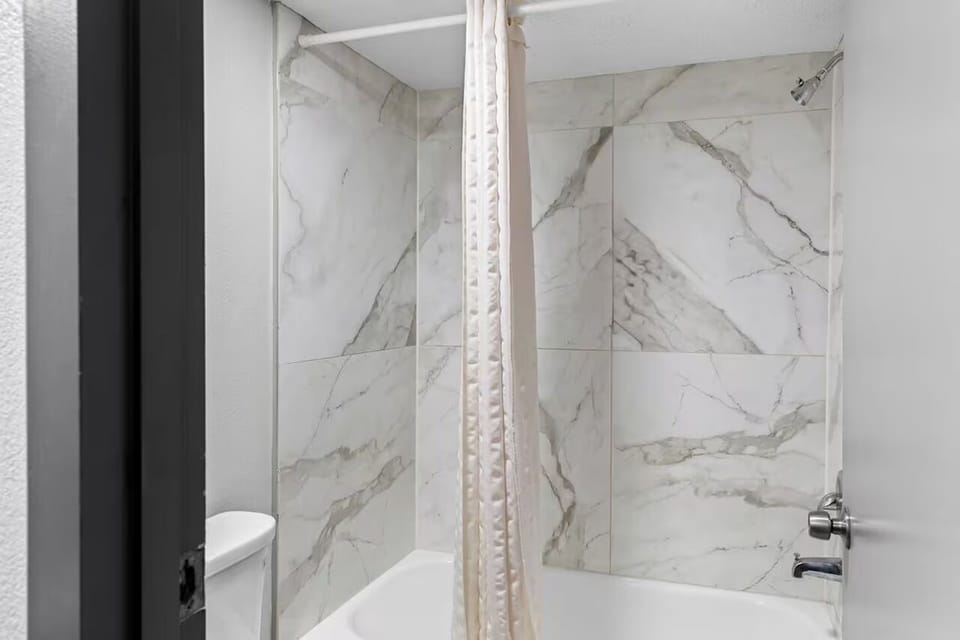 Rinse off in the clean tub-shower combo after a long day.