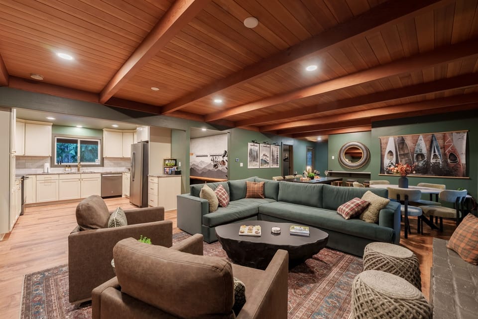 A wide-open gathering space with a huge sectional, cozy seating, and the fully equipped kitchen just steps away—perfect for groups to cook, relax, and spread out together.