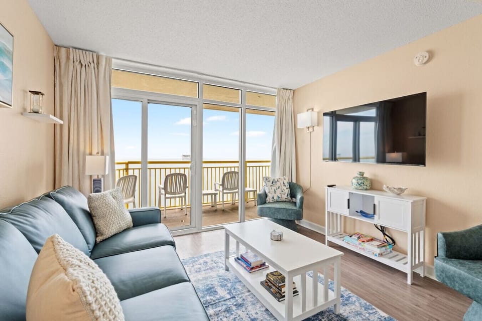 Sink into the leather couch in this oceanfront living room, complete with a 55` Vizio smart TV and direct balcony access.
