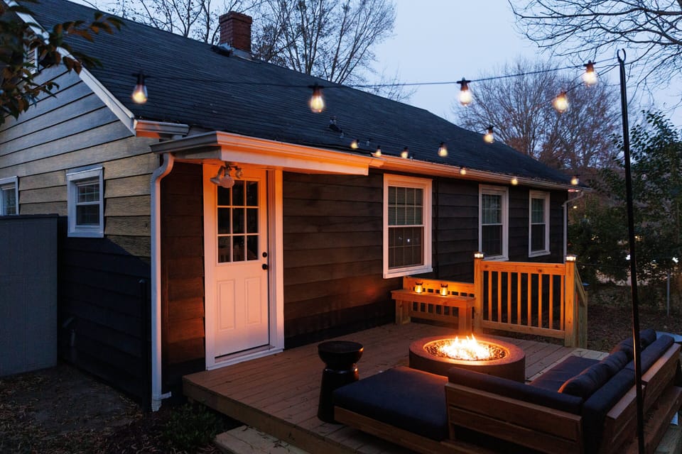 Private deck with modern outdoor sofa and fire pit under market lights