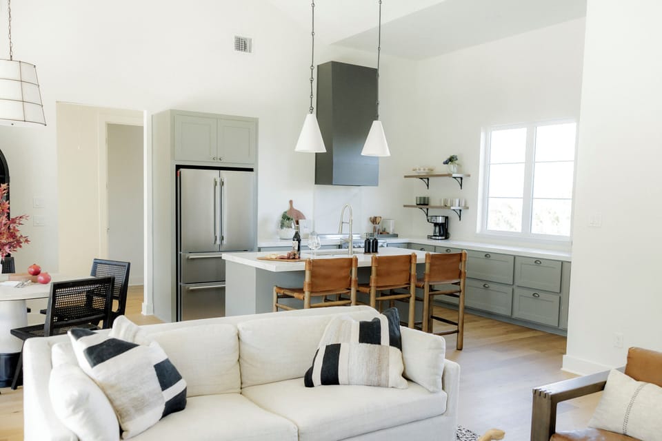 Sunlit open kitchen with island seating and vaulted ceiling charm.
