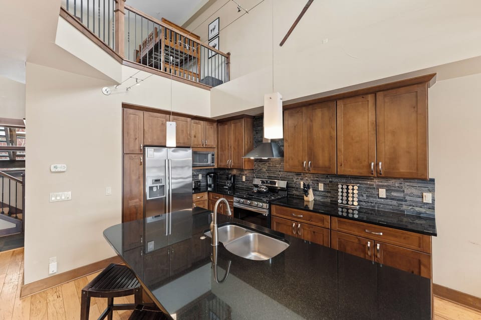 Luxury kitchen with stainless steel appliances and breakfast bar seating.