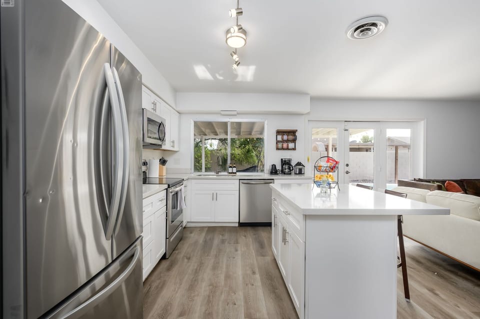 This modern fully stocked kitchen is filled with natural light and offers easy access to the backyard, making indoor-outdoor living effortless and enjoyable.