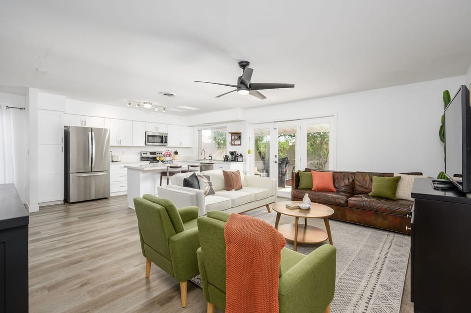 This bright, open-concept living space is ideal for gathering, featuring stylish seating, a modern kitchen, and seamless indoor-outdoor flow.