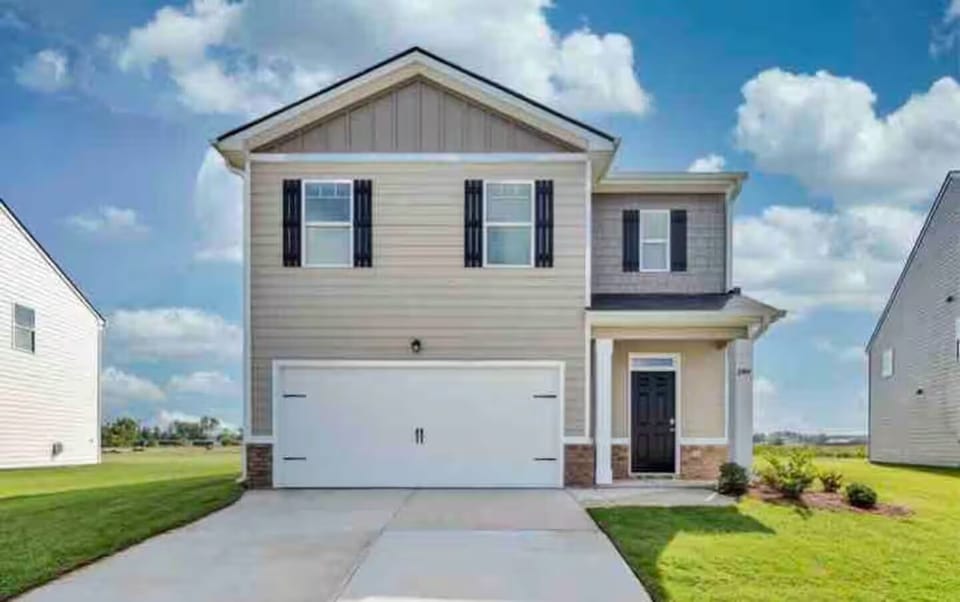 Clean, modern exterior with driveway parking and attached garage.