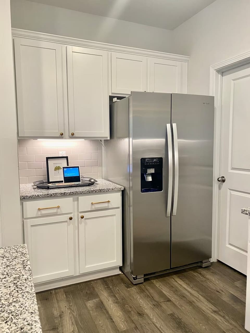 Modern kitchen with spacious fridge, ice maker, and ample cabinet space.