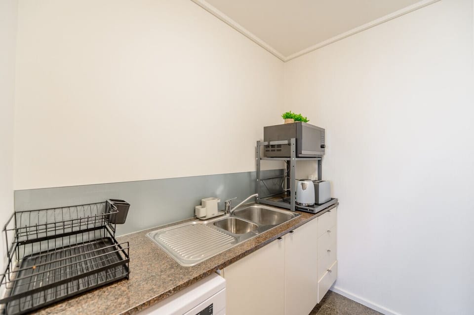 Kitchen - Marble top bench with sink cupboards and dish drying rack