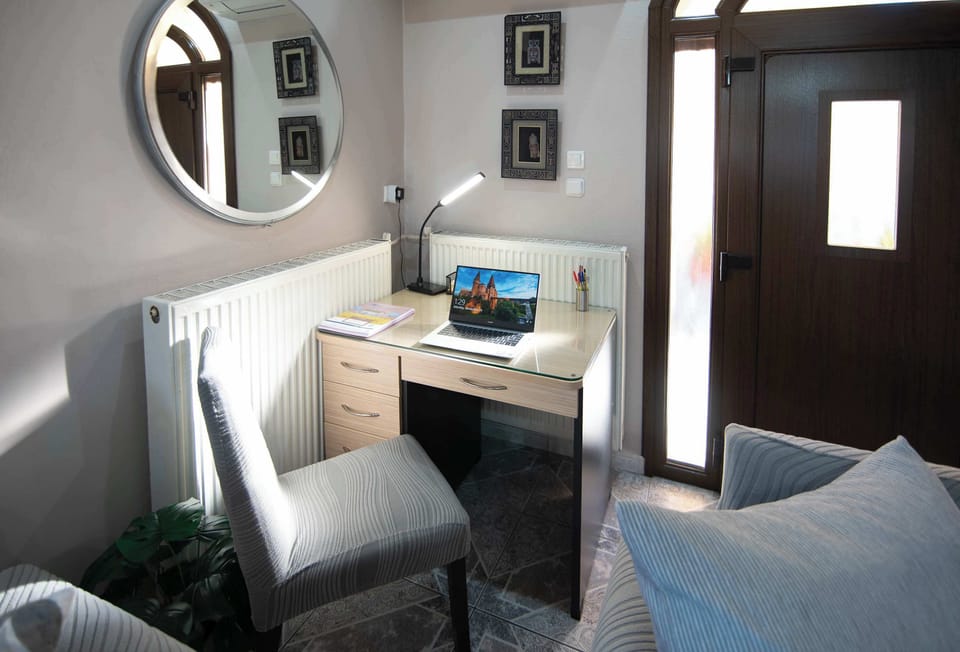 Quiet work corner with a comfortable chair and natural lighting, ideal for reading, writing, or remote work whenever needed.