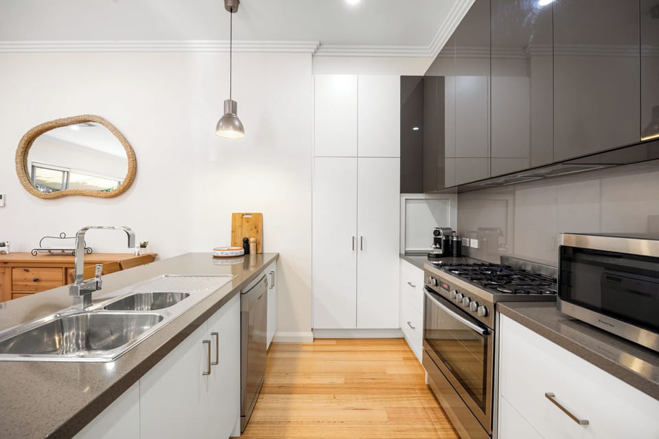 The modern kitchen features a gas cooktop, oven, microwave, air fryer, Nespresso machine, dishwasher, ample bench space and all essentials for simple meals at home.
