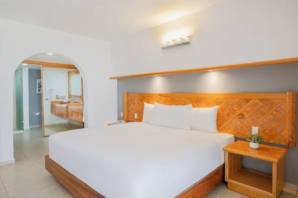 Unwind in a serene king bed with soft, warm lighting.