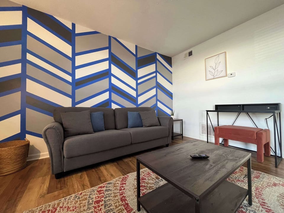 Living Room: Welcome to the living room! It's a functional space where you can hang out with your loved ones. We've even added a work desk in the corner, so you can get things done while still enjoying each other's company.