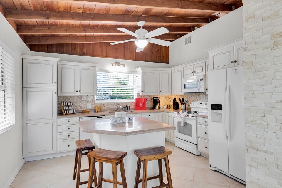 A charming kitchen featuring an island with comfortable seating for casual meals or morning coffee.