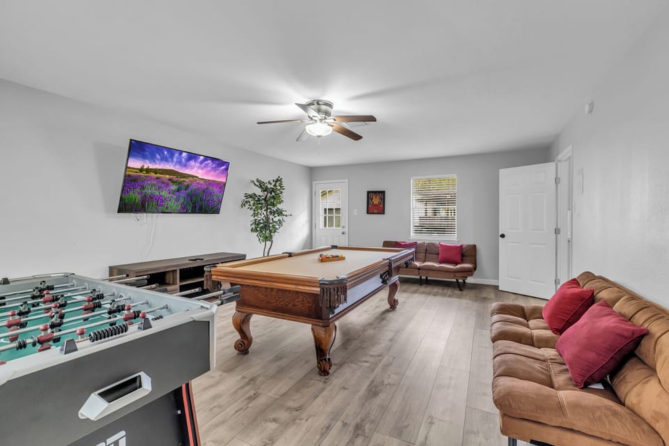 Game room with pool table, foosball, cozy sofa, and 65" Smart TV!